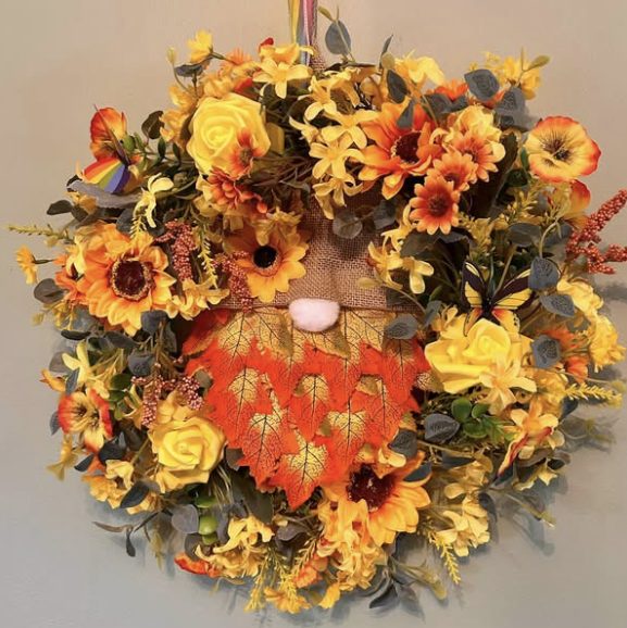 Sunflower and rose wreath with a gnome whose beard is made of orange leaves